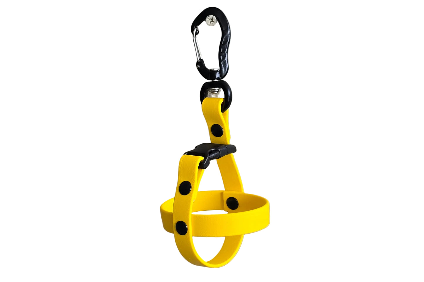 A clean studio photograph on a white background showing a single handcrafted yellow BioThane dog ball holder. The holder is formed by a crisscross BioThane strap secured by sturdy black rivets. At the top, a quick-release black buckle connects to a heavy-duty black aluminum carabiner with a swivel action and a screw-lock mechanism. The design illustrates a durable, easy-to-clean, and secure way to carry fetch balls hands-free. Note that no balls are included in Horizon.