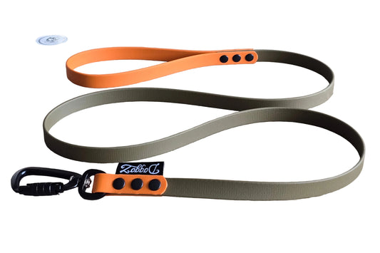 Olijfgroene BioThane hondenriem van DoggoZ met een oranje handvat en oranje accent, zwarte karabijnhaak, zwarte klinknagels en DoggoZ merklabel.