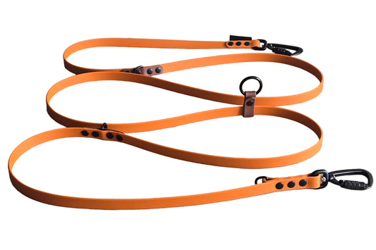 Multifunctionele, verstelbare handsfree BioThane hondenriem van DoggoZ in oranje met bruine accenten, twee zwarte karabijnhaken en zwarte hardware.
