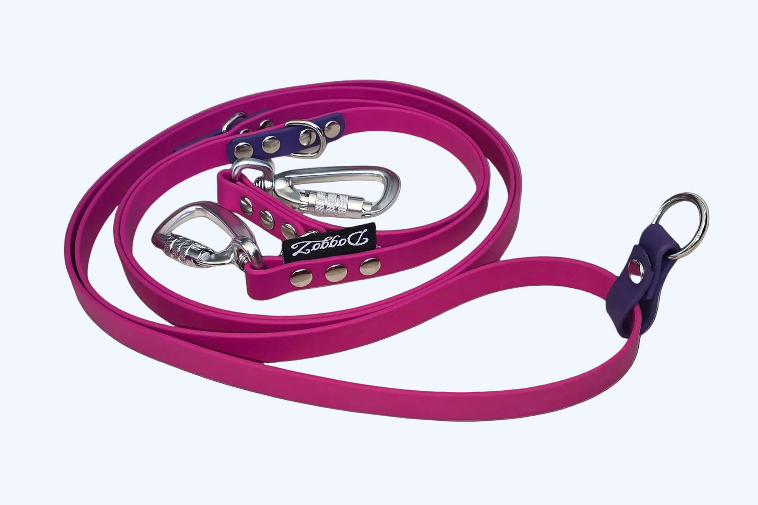 Full view of the DoggoZ Multi-Way Convertible Leash in pink BioThane with purple accents, showing the dual silver auto-locking carabiners and multiple attachment rings for hands-free or long-lead walking.