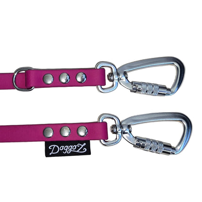 Close-up of the DoggoZ Multi-Way Convertible Leash in pink BioThane, showcasing two silver auto-locking carabiners, a silver D-ring, and the black DoggoZ logo tag secured with heavy-duty rivets.